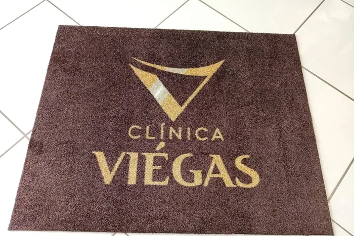 Tapete de nylon marrom com a logo da Clínica Viégas aplicada em dourado