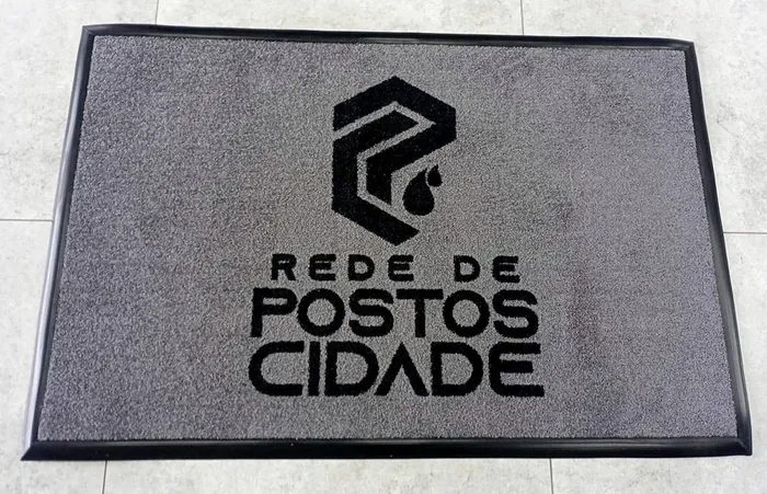 Tapete de nylon cinza com borda emborrachada preta e a logo da Rede de Postos Cidade