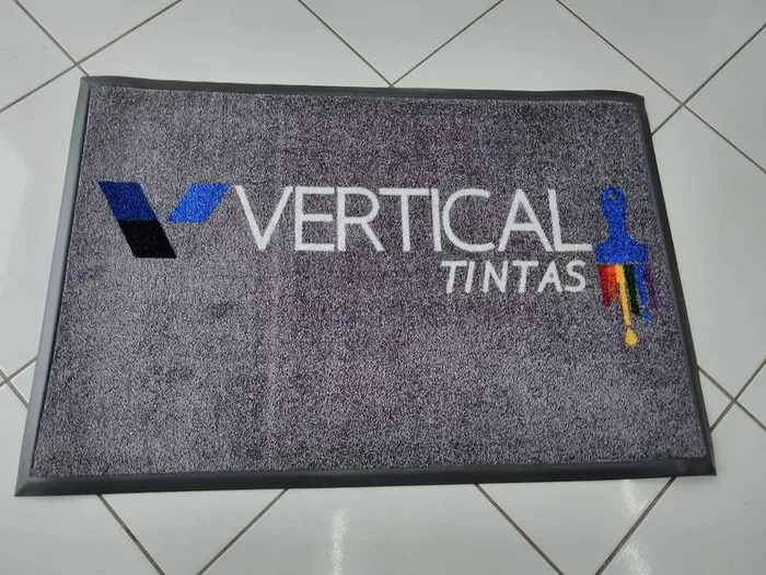 Tapete de nylon cinza com a logo colorida da Vertical Tintas