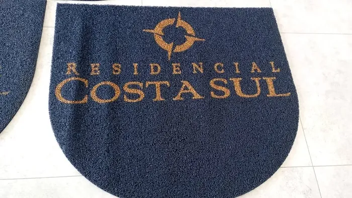 Tapete azul em formato de meia-lua com a logo do Residencial Costa Sul