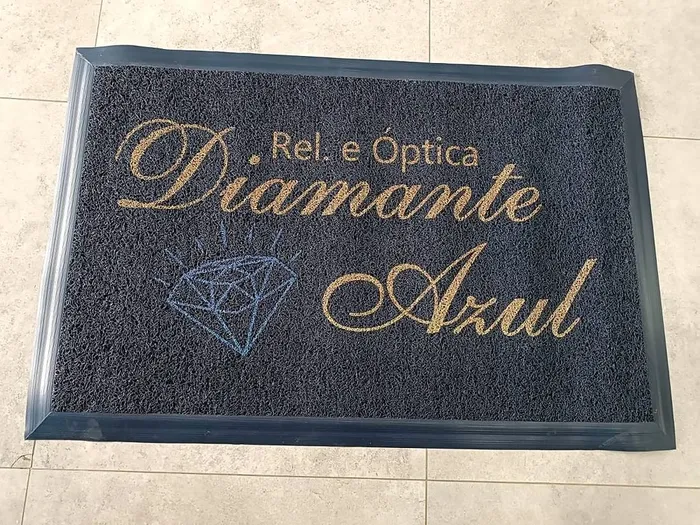 Capacho de vinil escuro com borda e o nome da relojoaria e óptica Diamante Azul em dourado