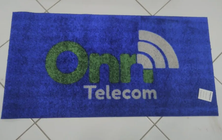 Tapete de nylon sintético azul sem borda, com a logo da Onn Telecom em verde e cinza